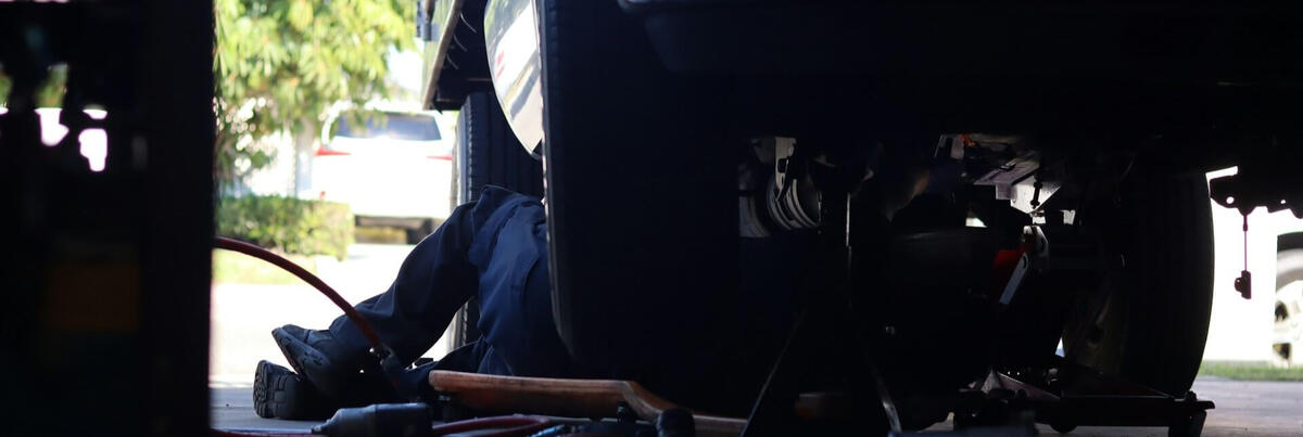 Mechanic cleaning tools after a mobile service – Maxamy Autocare Mechanic wiping down a ratchet tool with a cloth after completing a mobile car service, showcasing attention to detail and cleanliness.