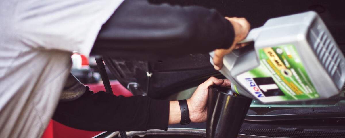 Mechanic cleaning tools after a mobile service – Maxamy Autocare Mechanic wiping down a ratchet tool with a cloth after completing a mobile car service, showcasing attention to detail and cleanliness.