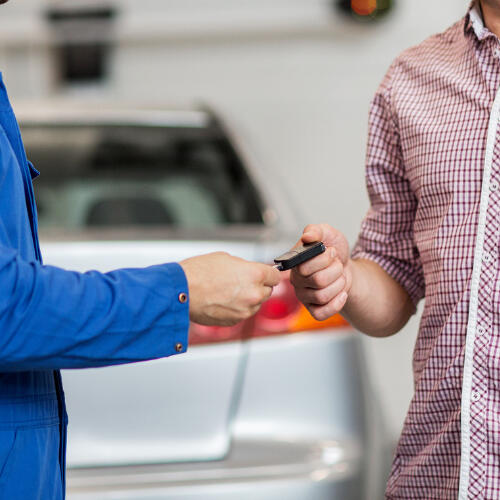 Handing Over Car Keys for Mobile Service Close‑up of a customer handing car keys to a mechanic, symbolising convenient mobile car servicing and repairs in Slough, Maidenhead and Windsor.