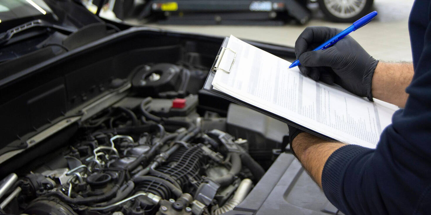 A mobile mechanic inspecting a car’s tires during a winter health check in Berkshire.